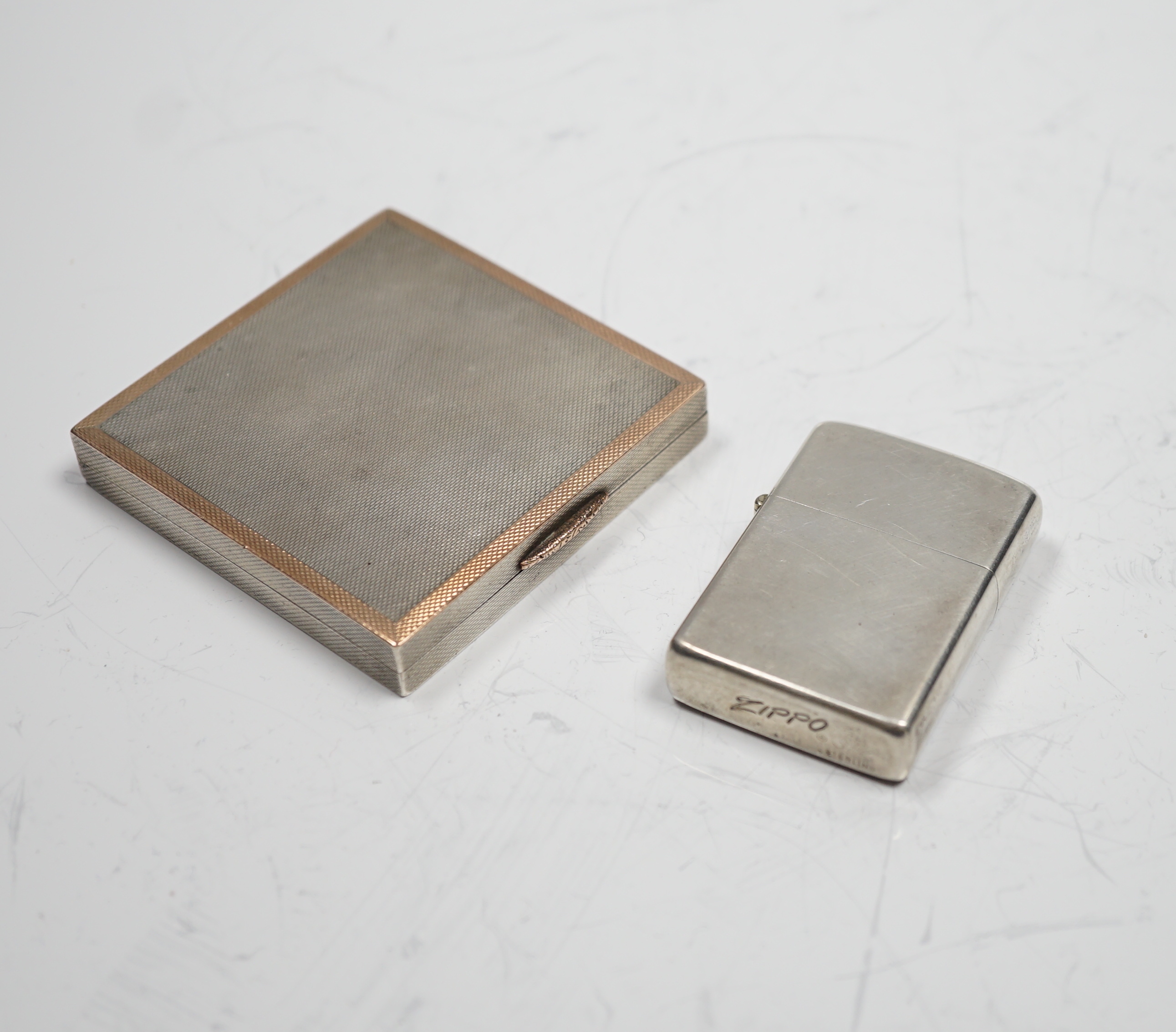 A sterling cased Zippo lighter, 71mm, together with a 1930's engine turned silver cigarette case.